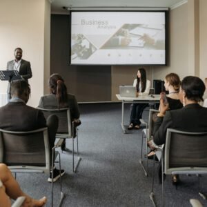 A diverse group of adults attending a presentation in a conference room setting.